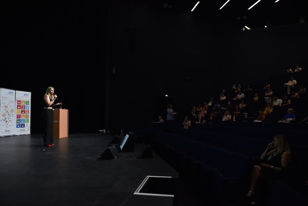 Stéphanie Julet, sur scène, en train de donner une conférence devant une salle pleine
